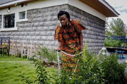 Image of Ruth Namachanja watering plants at her place